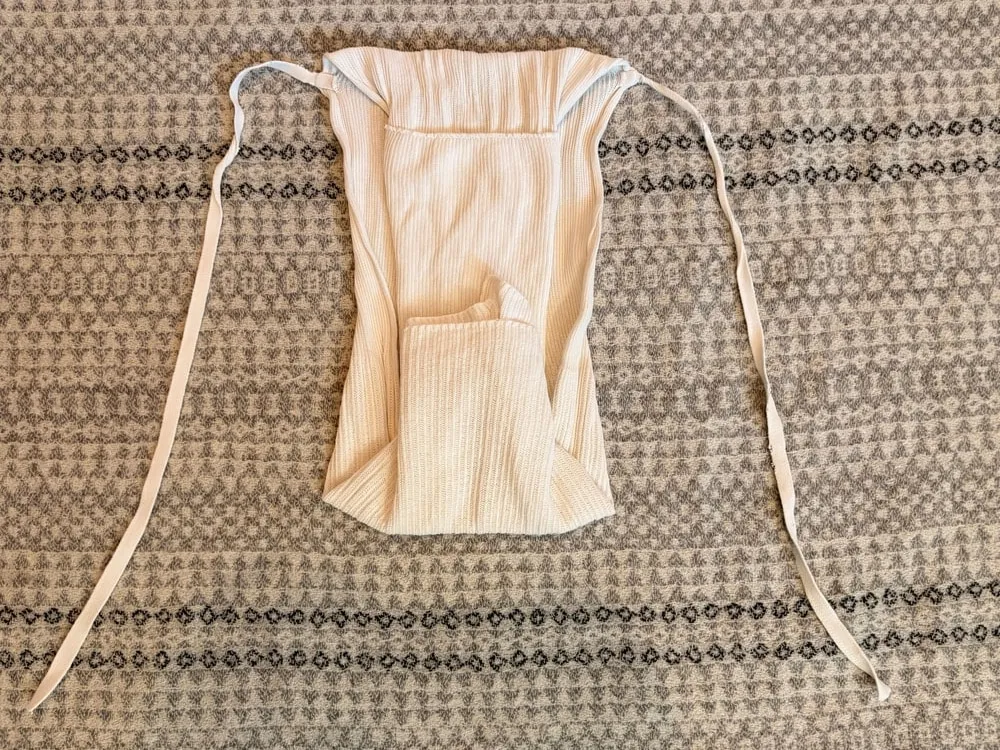 Step 6: The shortened front panel tucked inward, with the ties still spread out.