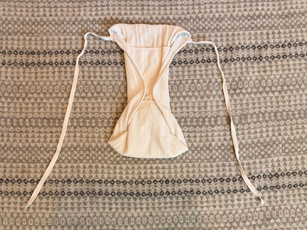 Step 7: The nappy folded into a narrow hourglass shape, with the ties still underneath.